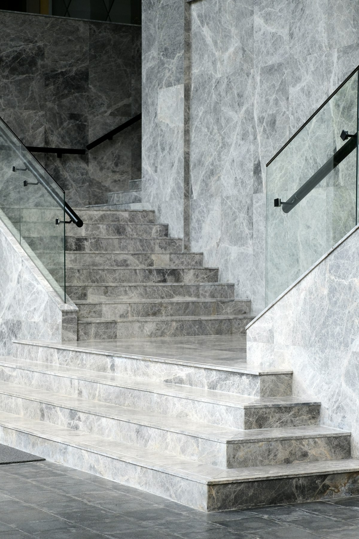 Frameless glass stair railing with adjustable-angle hardware